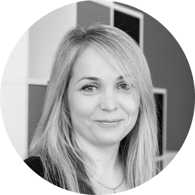 Czarno-biały portret uśmiechniętej kobiety z długimi blond włosami.