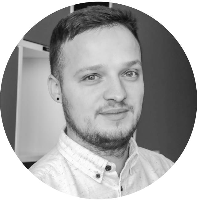 Czarno-biały portret mężczyzny z krótkimi włosami i zarostem, ubranego w koszulę z kołnierzykiem.